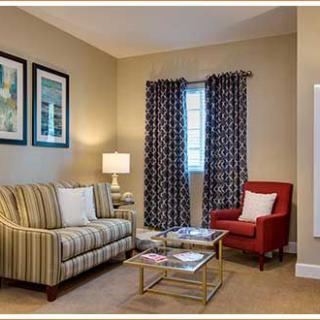 Cozy living room with a striped sofa, red armchair, and elegant decor.