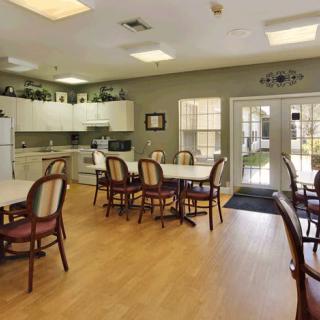 A bright and spacious kitchen dining area with several tables and chairs.