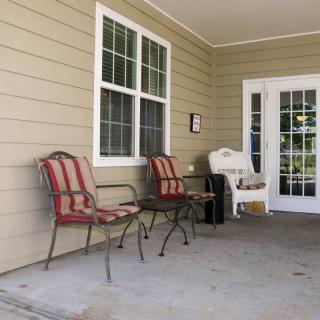 A cozy porch with outdoor seating and a window overlooking the area.