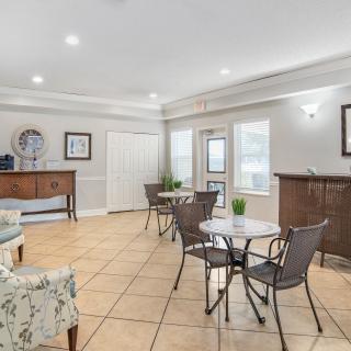 A bright and modern living room with tables, chairs, and decorative elements.