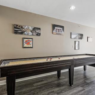 A stylish shuffleboard table complemented by modern wall art in a contemporary game room.