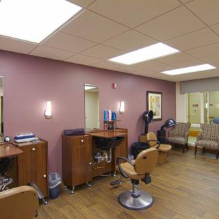 A well-lit and organized salon interior with styling chairs and a waiting area.
