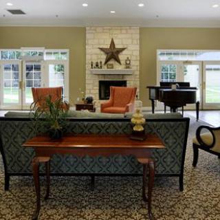 A cozy living room with a fireplace, seating area, and stylish furniture.