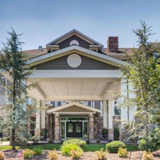 A grand entrance of a building surrounded by landscaping and trees.