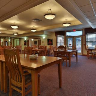 A quiet library interior with wooden tables and chairs arranged for reading and study.