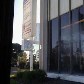 A view of a modern commercial building with large glass windows and prominent signage.