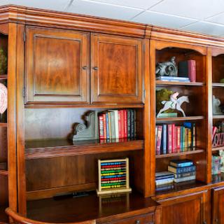 A beautifully crafted wooden bookshelf filled with an assortment of books and decorative pieces.