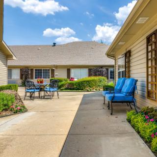 A sunny courtyard with patio furniture and well-maintained landscaping.