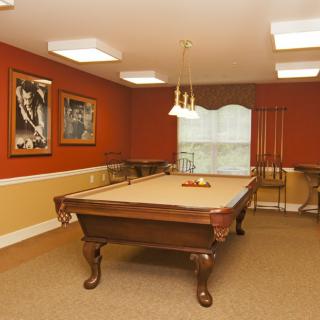 A well-lit billiard room with a pool table and stylish decor.