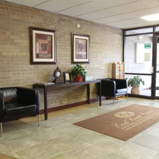 A welcoming lobby area featuring modern furniture, artwork on the walls, and a touch of greenery.