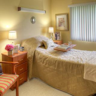 A cozy bedroom with a single bed, nightstands, and soft lighting.