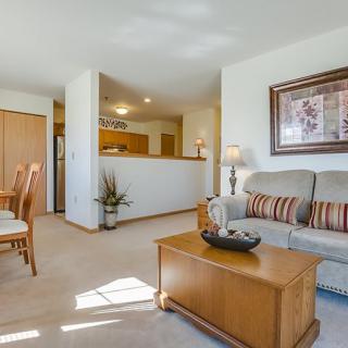 A cozy living room with a sofa and coffee table, adjacent to a kitchen and dining area.