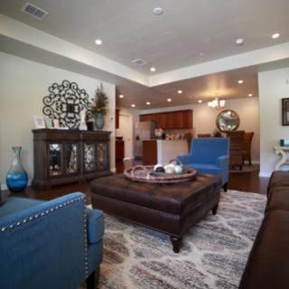 A stylish living room featuring blue accent chairs, a central coffee table, and elegant decor.