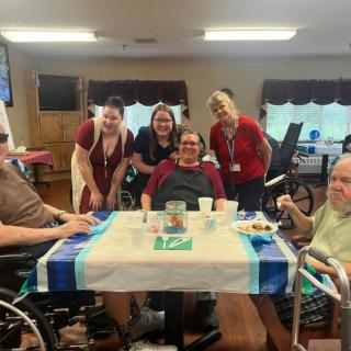 A group photo of seniors along with their caregivers inside a community area.