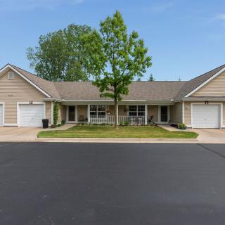 A suburban duplex with well-maintained lawns and a central tree.