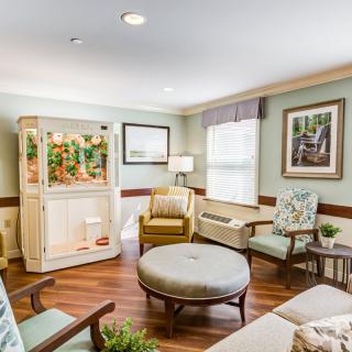 A cozy living room with comfortable seating and a large aquarium.