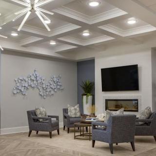 A modern living room featuring comfortable seating, wall art, and a large television.