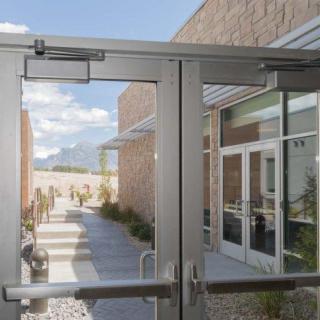 View through glass doors to an exterior pathway under a clear sky.