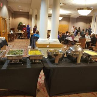 A buffet setup in a conference room with attendees enjoying the gathering.