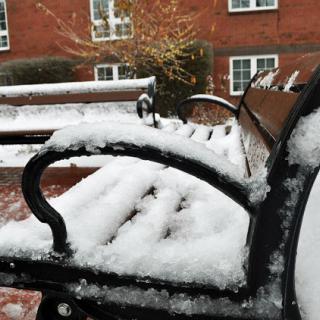 A snowy bench adorned with a fresh layer of snow, capturing the essence of winter.