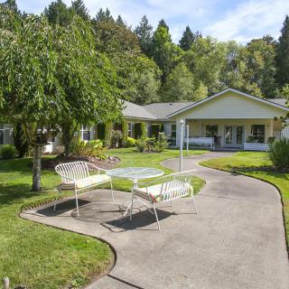 A charming house with a lush garden and outdoor seating area.