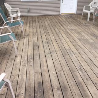 A spacious wooden deck with outdoor chairs arranged for relaxation.
