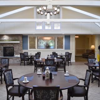 A spacious and modern dining area featuring elegant tables, stylish chairs, and a bright chandelier.