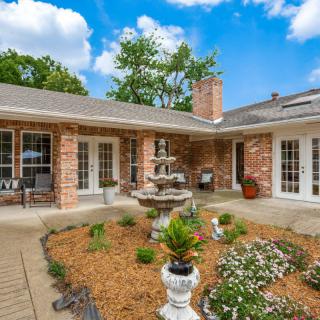 Charming brick house with a beautifully landscaped courtyard and fountain.