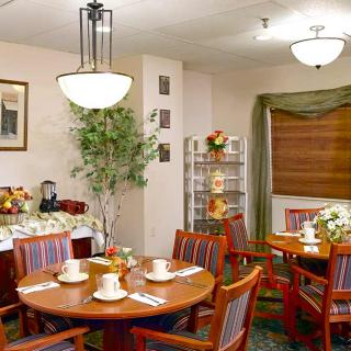 A cozy dining area with neatly set tables and warm lighting.