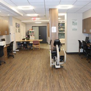 A spacious and well-lit office workspace featuring modern furniture and a cozy atmosphere.