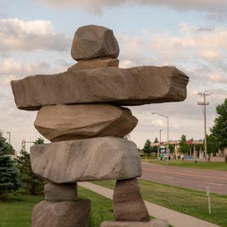 A large stone sculpture resembling an Inukshuk, symbolizing friendship and guidance.