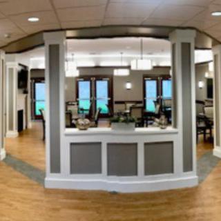 A modern reception area with wood flooring and stylish lighting fixtures.