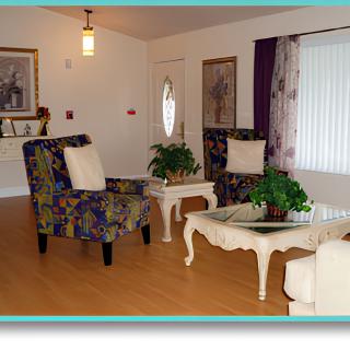 A cozy living room with patterned chairs, a white coffee table, and decorative artwork.
