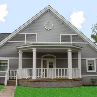 A gray residential house with a prominent front porch and gabled roof.