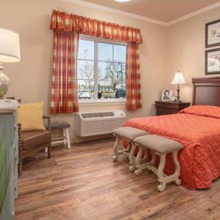 A cozy bedroom with warm decor and hardwood flooring.