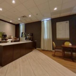 A modern office meeting room with a table, chairs, and refreshments.