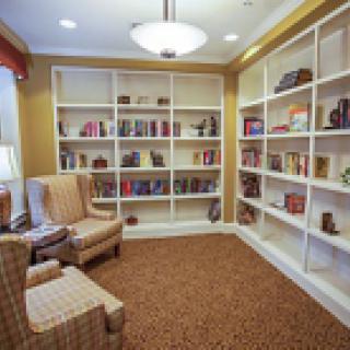 A cozy reading room with bookshelves and comfortable chairs.