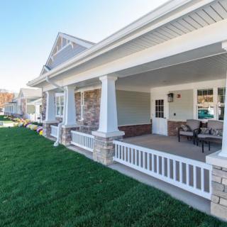 A well-maintained house with a spacious front porch and green lawn.