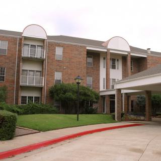 A residential apartment building with a landscaped entrance.