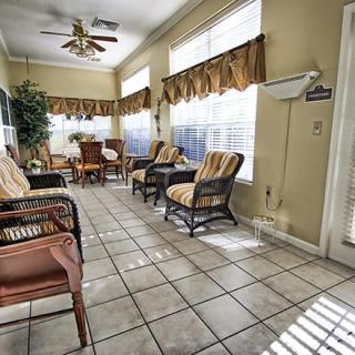 A cozy waiting room with wicker chairs and large windows letting in sunlight.
