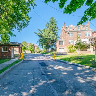 A peaceful suburban street lined with houses and trees on a sunny day.