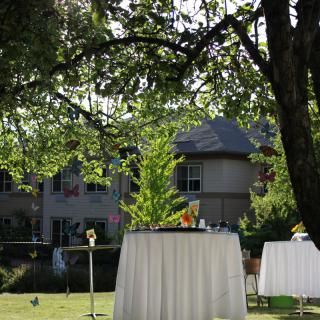 A beautifully set outdoor event with tables in a garden setting.