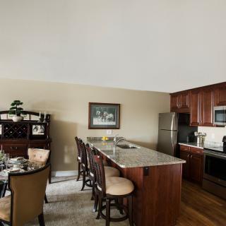 A modern kitchen and dining area with a large countertop and seating.