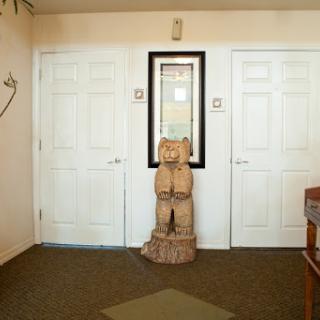 A cozy entrance featuring double doors, a mirror, and a wooden sculpture as decor.