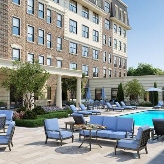 A luxurious hotel with a stylish outdoor pool area and comfortable seating.