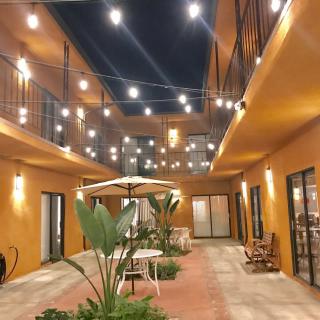 A warmly lit courtyard with string lights and outdoor seating at night.