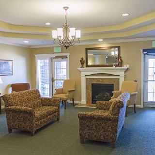 A cozy living room with comfortable seating, a fireplace, and elegant lighting.
