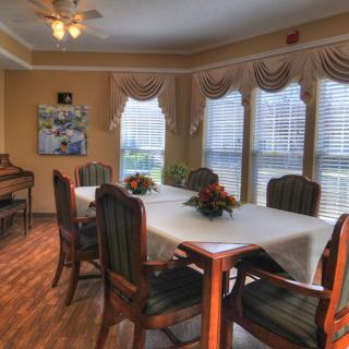A cozy dining room with a set table and large windows.