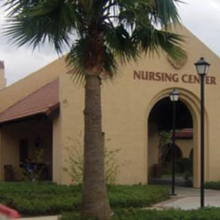 A nursing center building with a palm tree in front and an arched entrance.