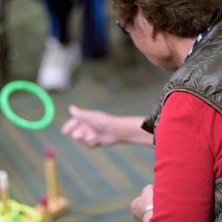 A person playing a ring toss game indoors.